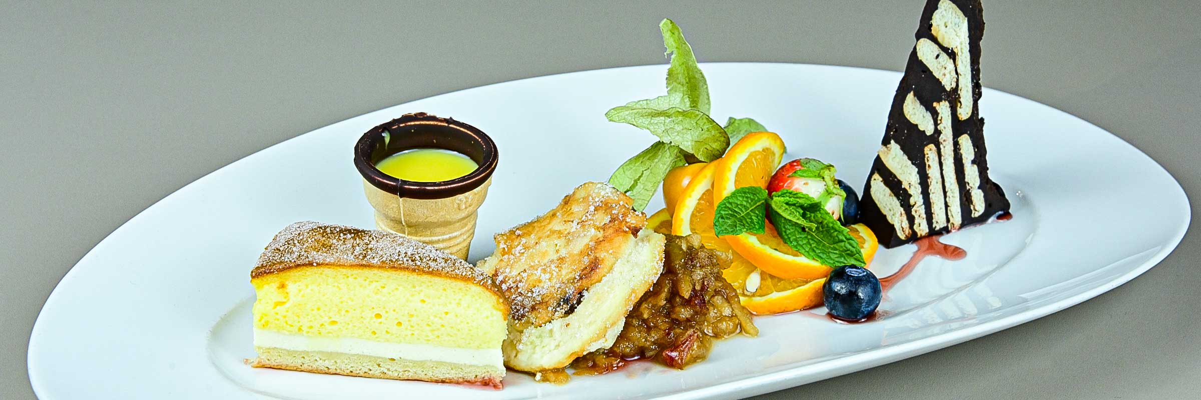 Sächsische Dessertkomposition mit kaltem Hund, Eierschecke, Quarkkeulchen mit Apfelkompott und einem Eierlikör